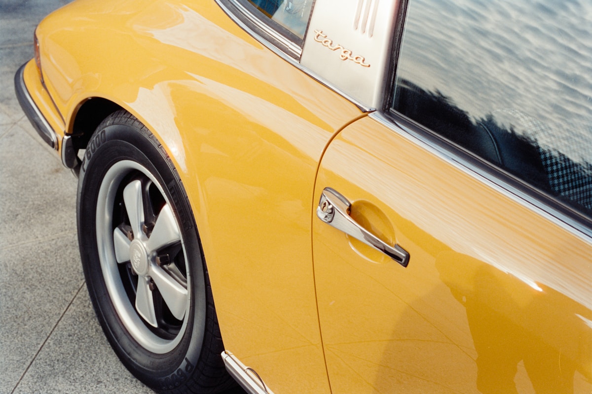 Close-up of a vintage yellow sports car door.