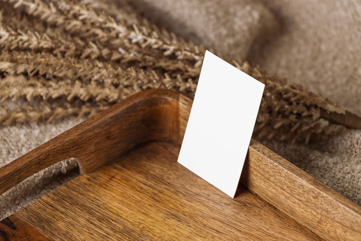 Carton blanc sur une table en bois avec un tapis marron.