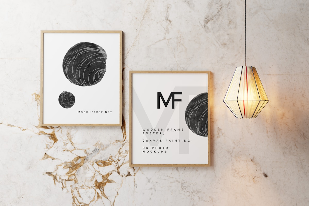 Cadres en bois avec motifs géométriques, lampe suspendue, fond de marbre.