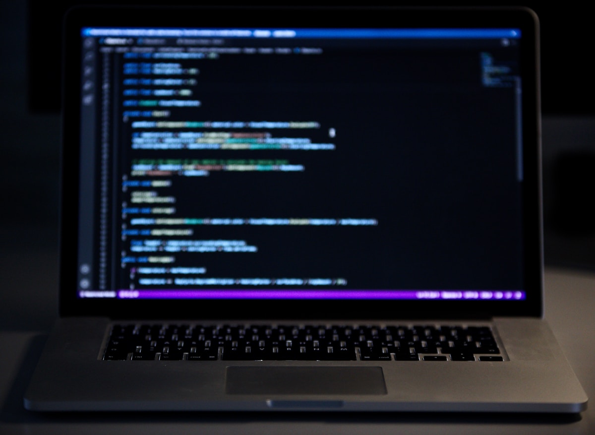 Code d'ordinateur sur un écran d'ordinateur portable sombre.