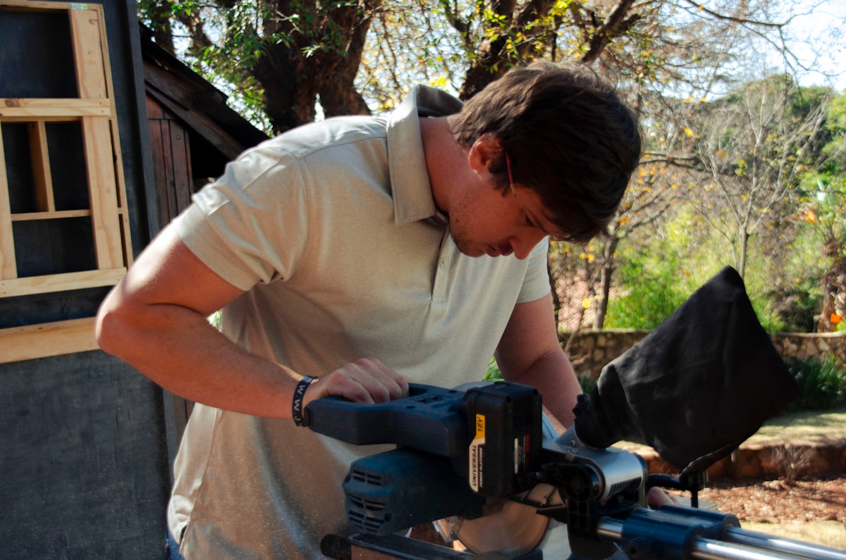a man using a circular saw to cut a piece of wood