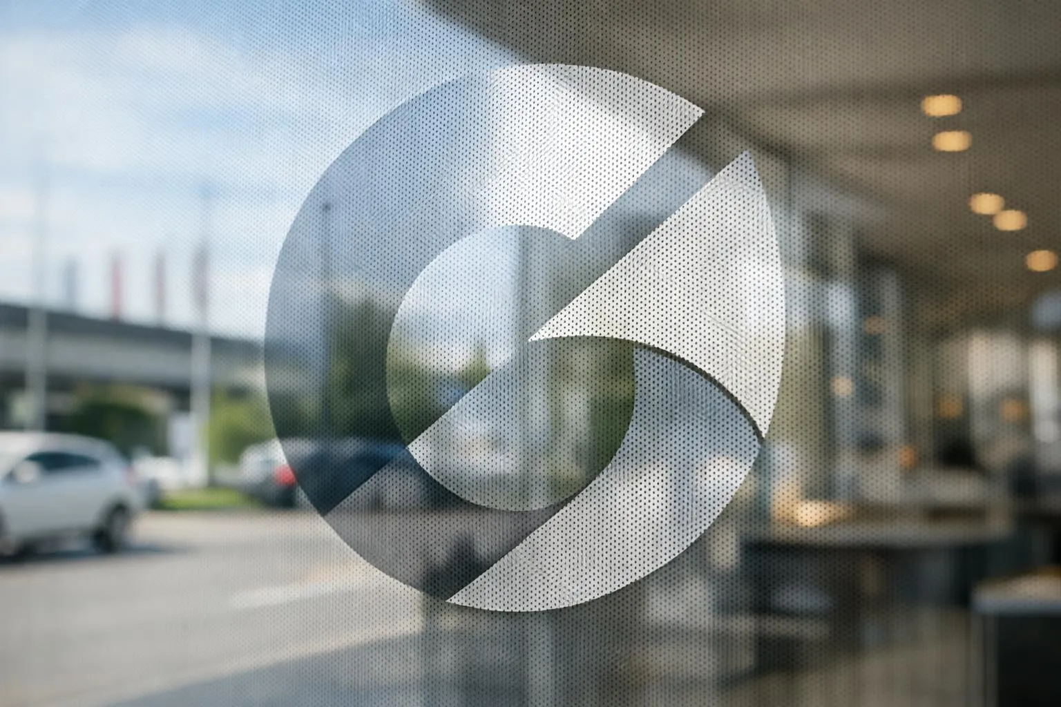 Close-up of high-quality perforated window decal on shop glass showing professional branding with see-through effect, modern Swiss retail environment in Crissier, natural daylight filtering through micro-perforated adhesive film, no text or letters visible