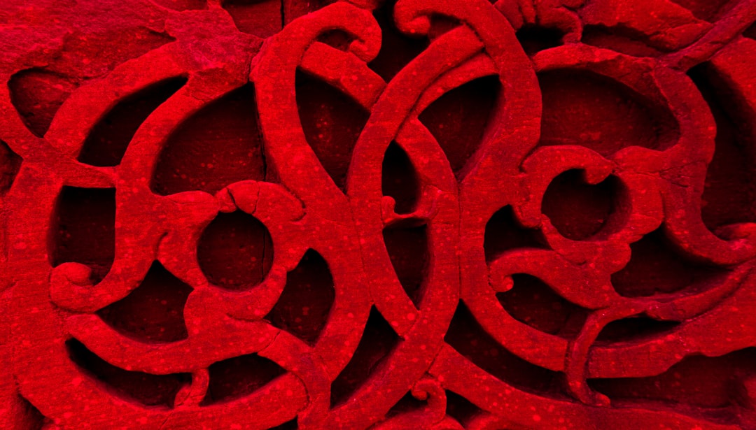 "Motif abstrait rouge original pour flocage vêtements événementiel, lignes tourbillonnantes complexes."
