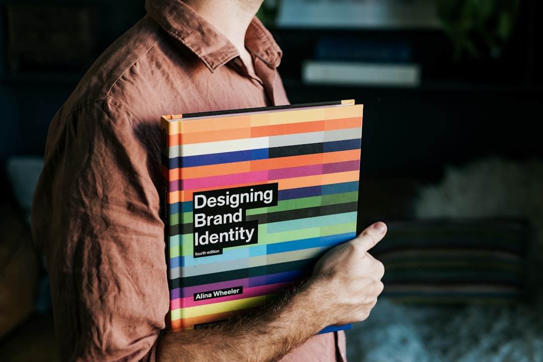 Un homme tenant un livre sur la création d'identité de marque, illustrant l'importance du branding pour les PME.