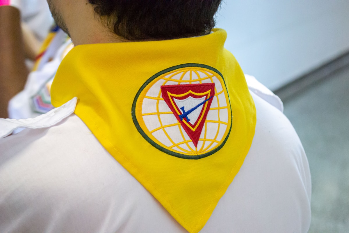Veste jaune avec logo coloré représentant un globe et une flèche.