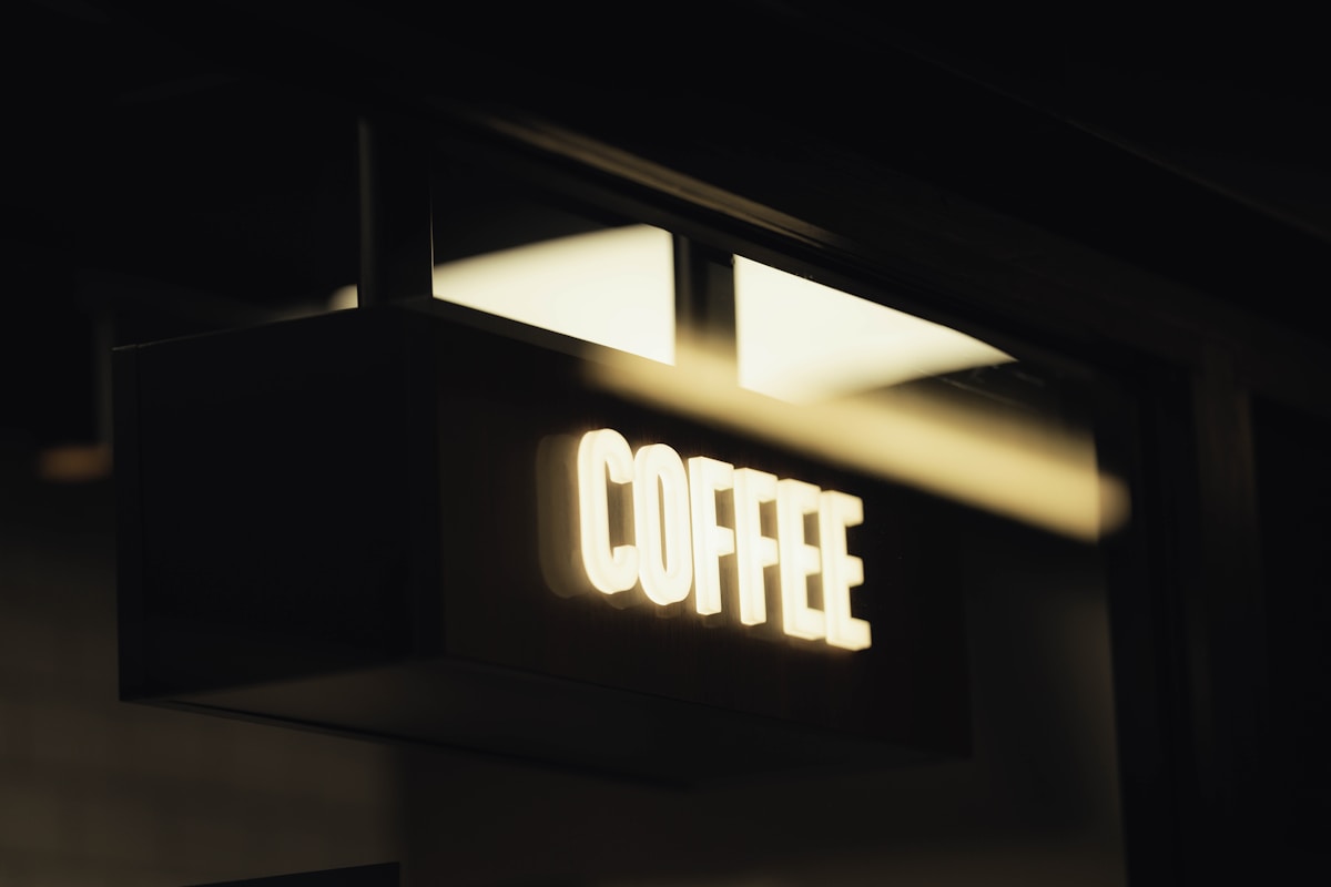 Enseigne lumineuse de café dans un environnement sombre.