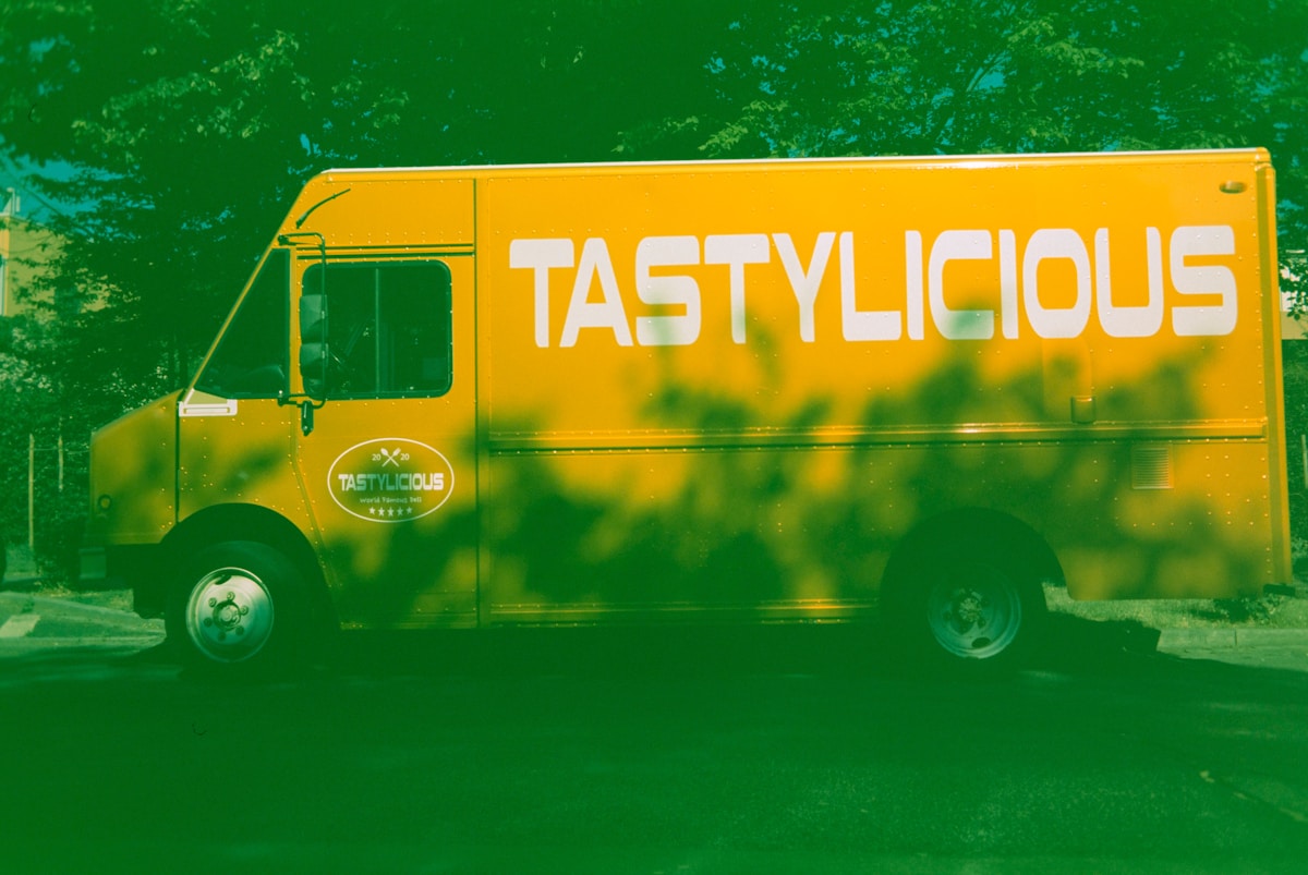 Camion de restauration rapide jaune avec le texte "Tastylicious".