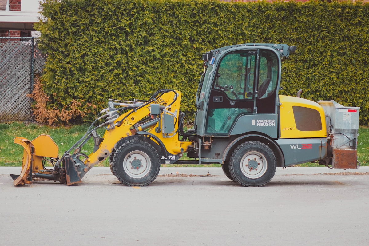 Chargeuse sur pneus jaune et grise avec équipement de chantier.