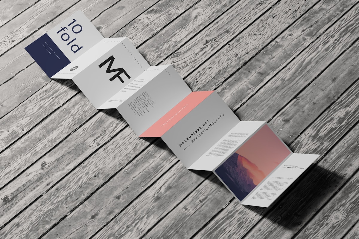 Brochures et documents sur un fond de planches de bois grisées.