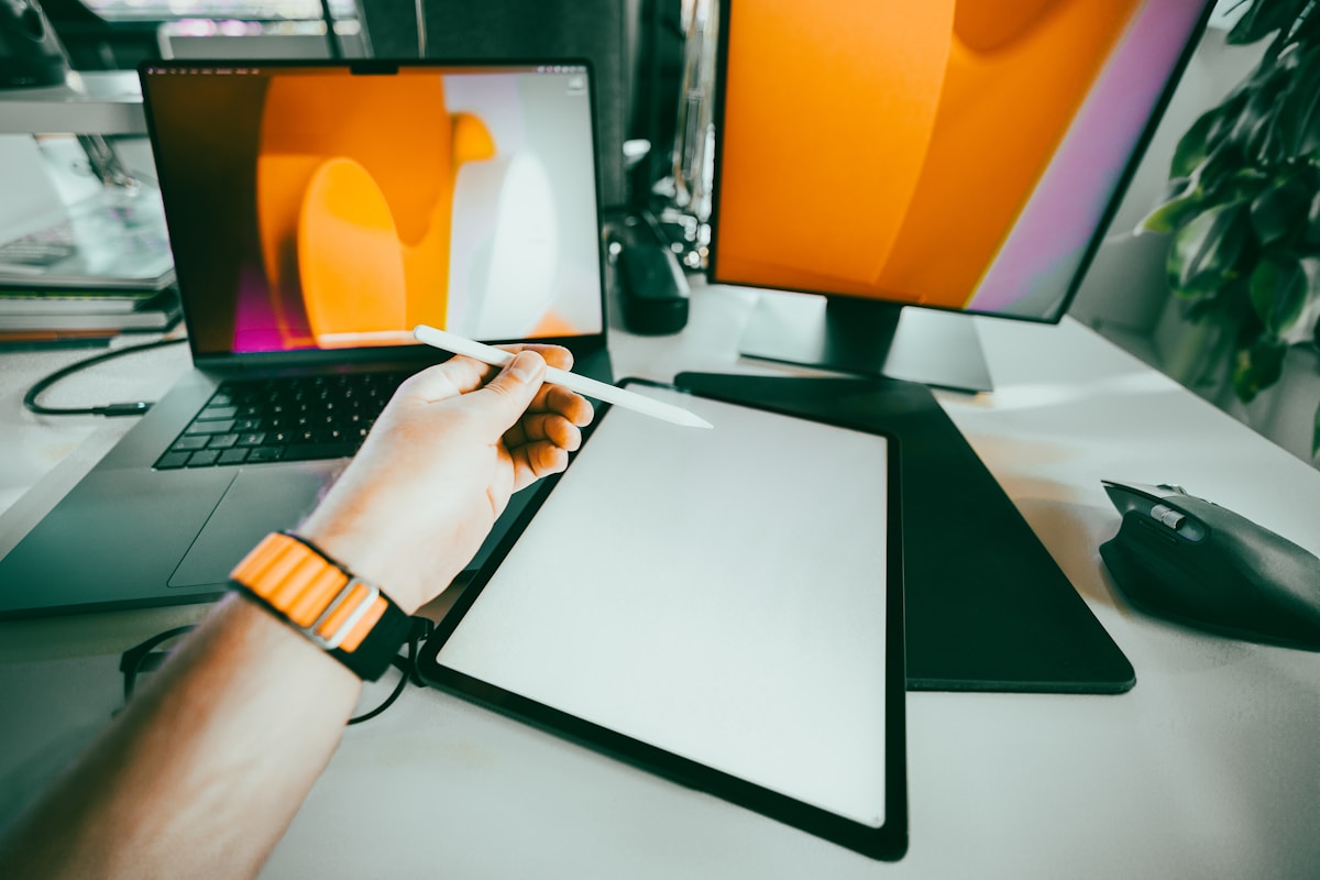 Espace de travail numérique avec ordinateur portable, tablette graphique et accessoires.