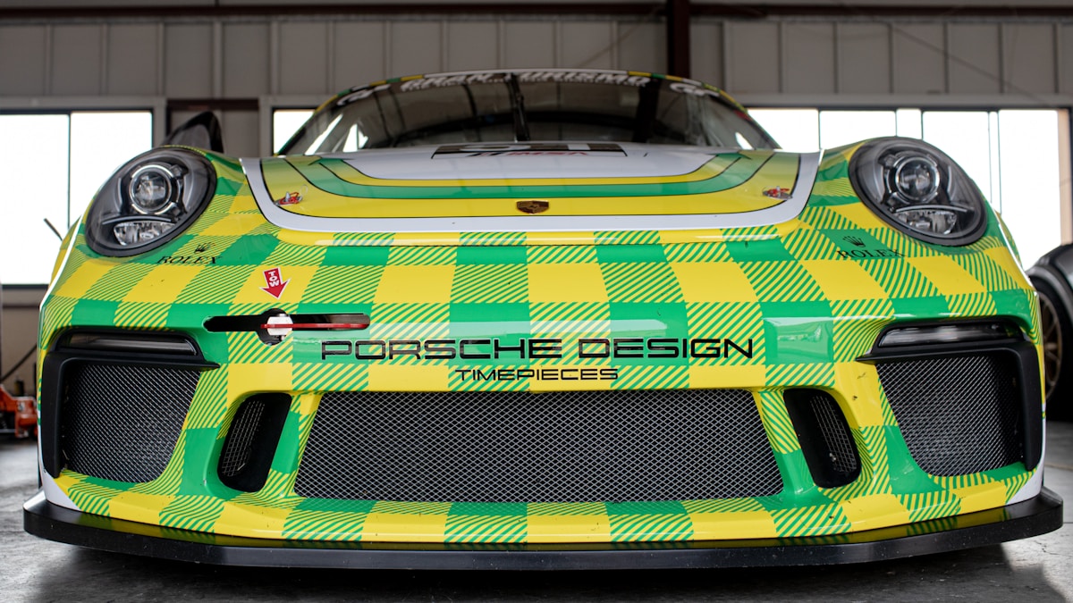 Voiture de course Porsche aux couleurs vives et motif géométrique.