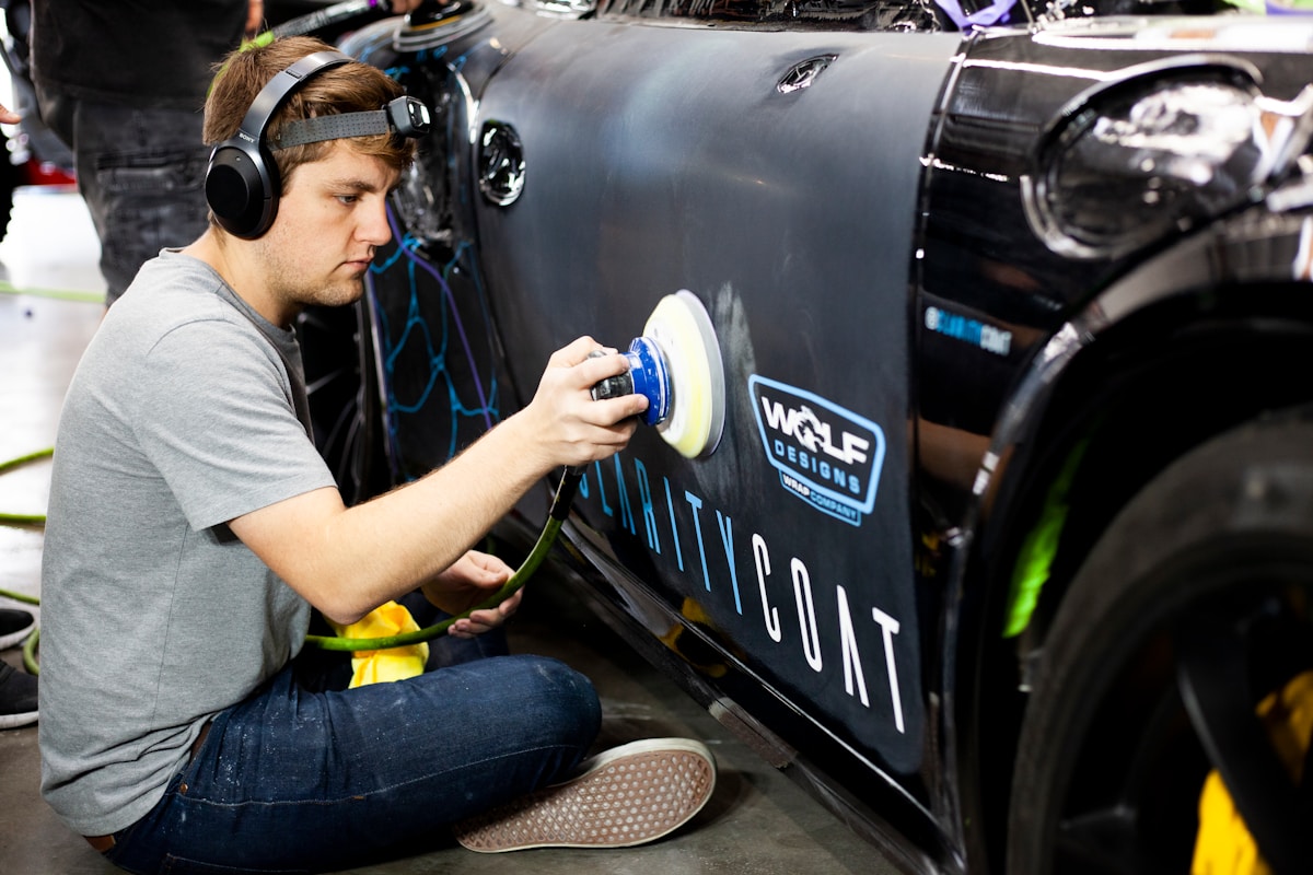Homme travaillant sur un véhicule avec un logo "Weld Design" sur le côté.