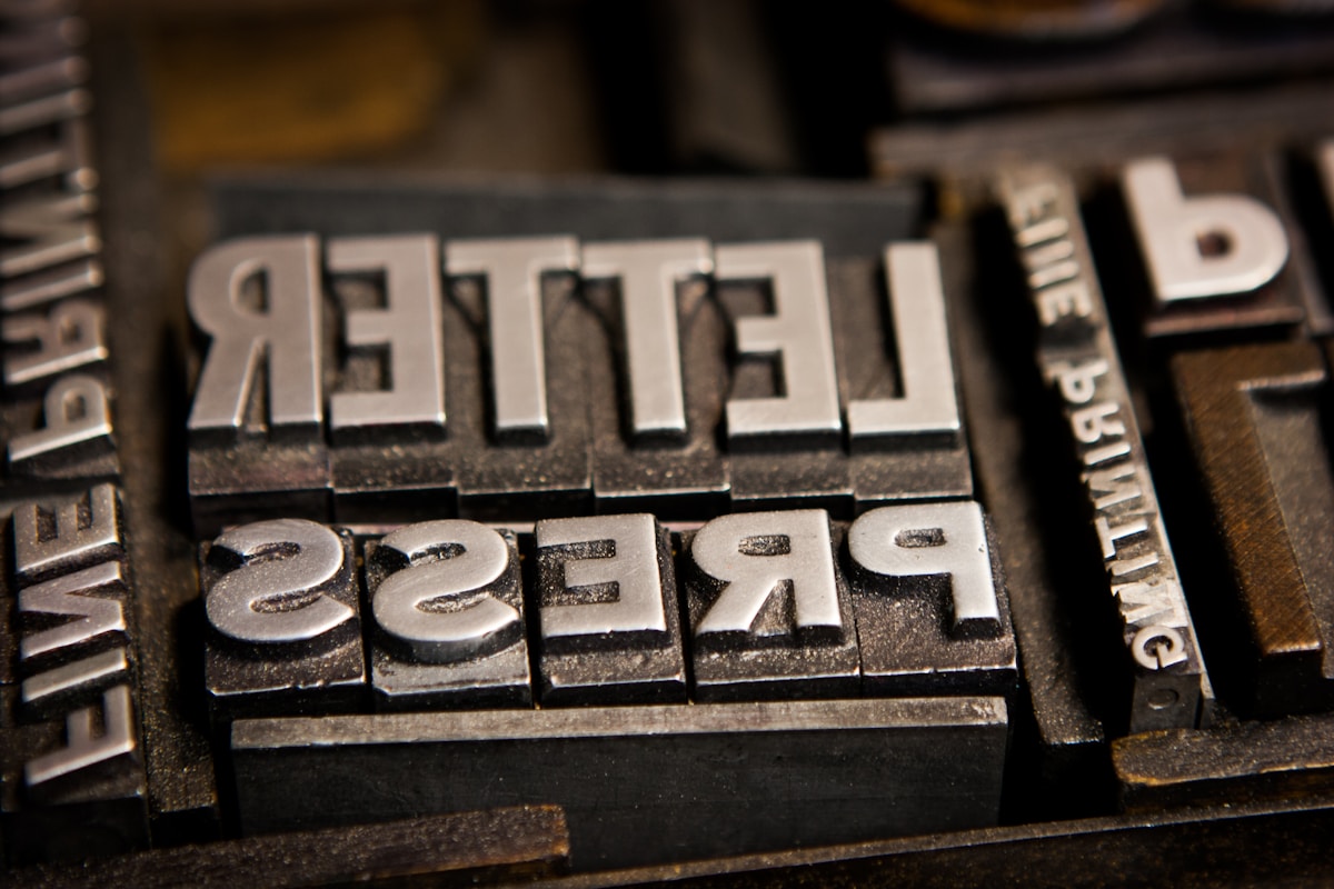 Lettres de métal formant le mot "Retell" sur un fond sombre.