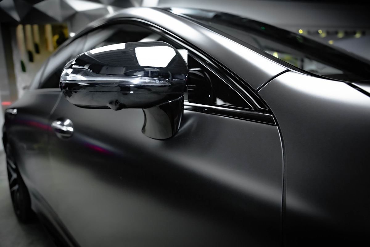 Voiture noire brillante avec rétroviseur latéral.