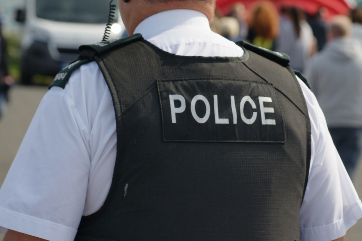 Veste de police noire avec le texte "POLICE" en blanc.