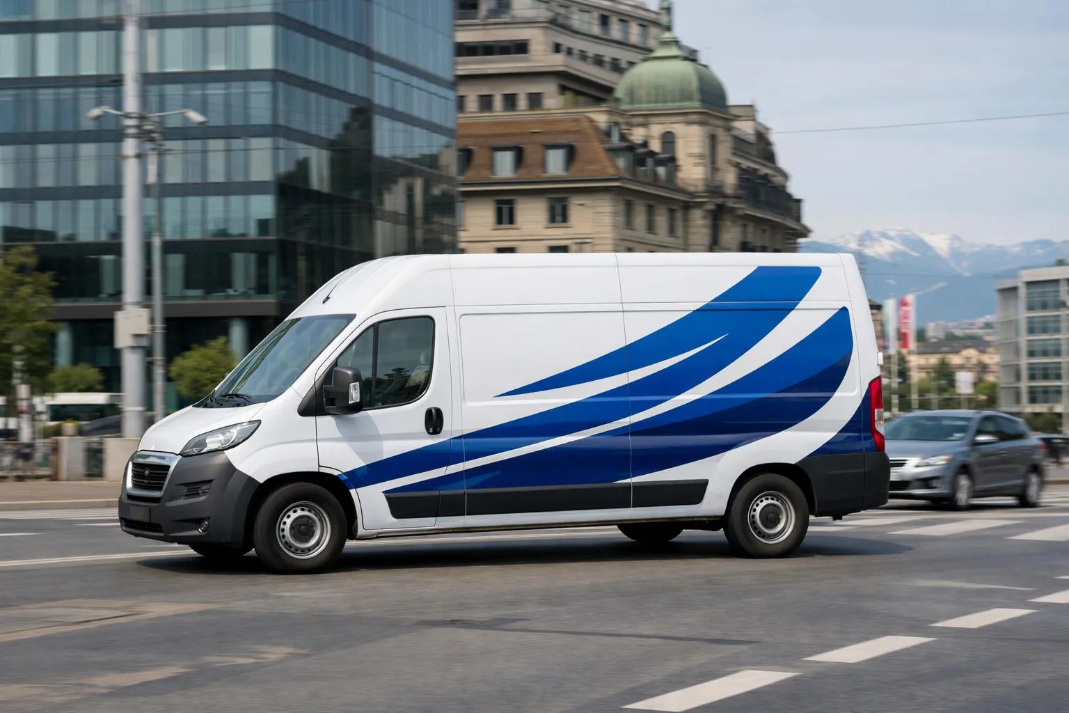 Fourgon de livraison blanc avec graphiques bleus sur la carrosserie.