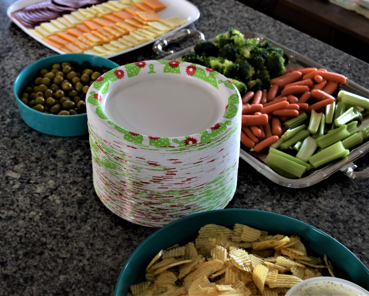 Plateau de légumes, de chips et de plats préparés sur un comptoir de cuisine.