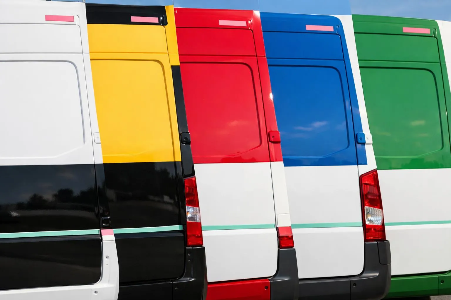Rangée de fourgons de livraison colorés - blanc, jaune, rouge, bleu, vert.