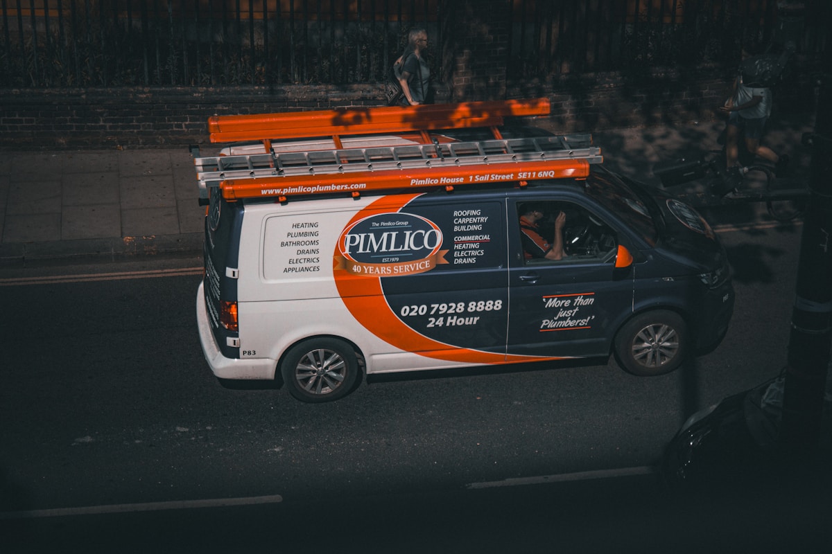 Fourgonnette de service Pimlico Plumbers avec équipement et coordonnées.