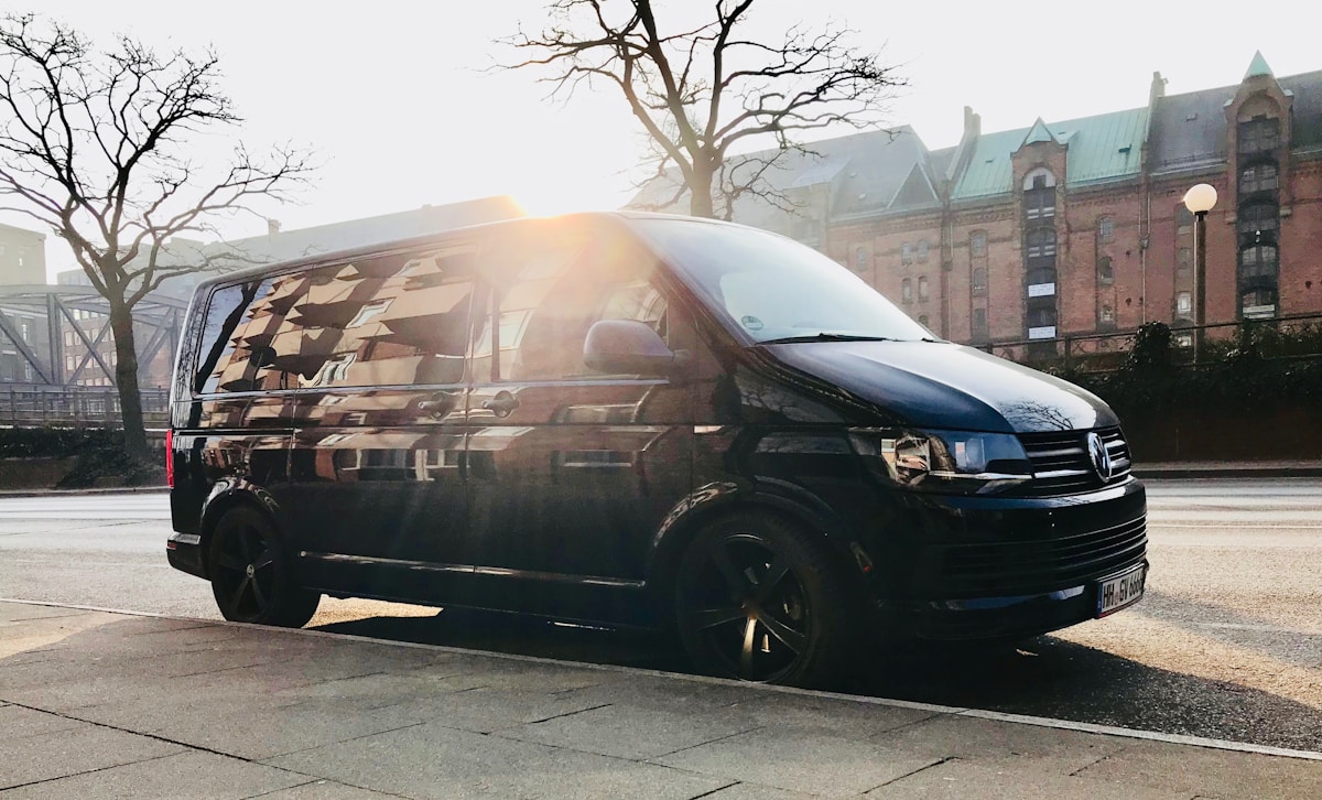 Camionnette noire avec motif de camouflage, garée dans une ville.