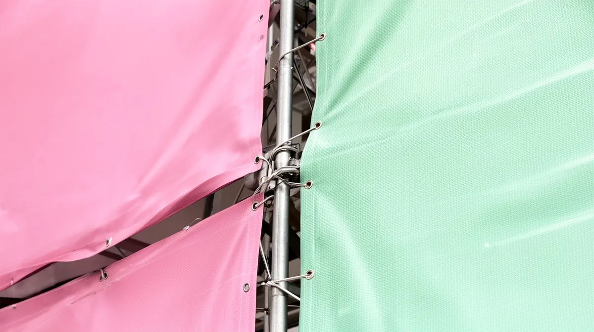 Toile rose et verte tendue sur une structure métallique.