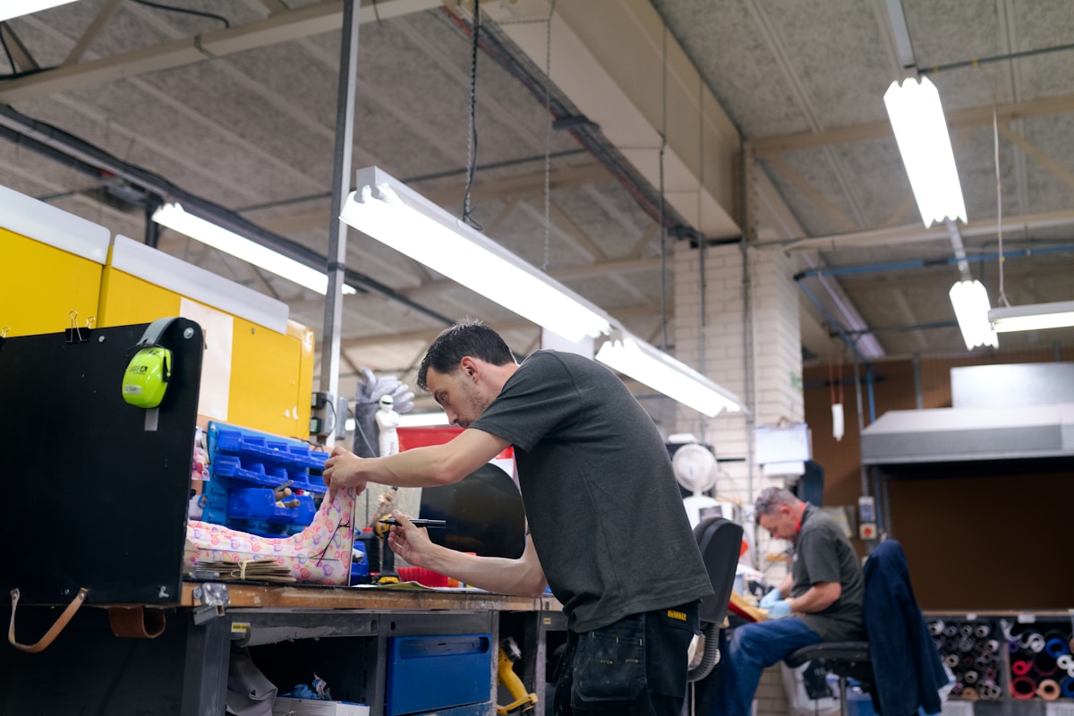 Homme travaillant dans un atelier, réparant ou assemblant un équipement.
