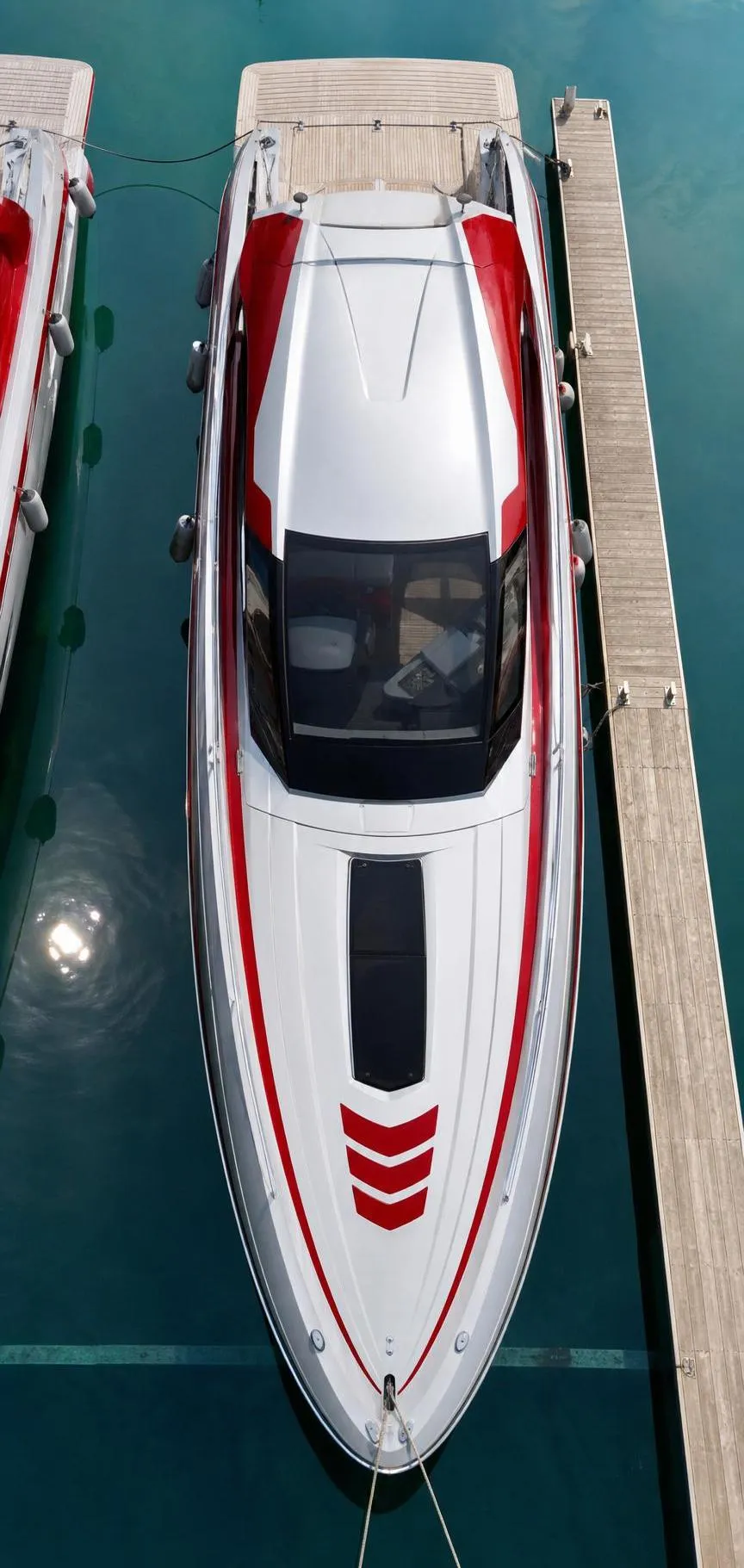 Bateau de plaisance blanc et rouge amarré sur un quai.