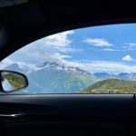 "Nuages blancs sur des montagnes enneigées, avantages des films teintés voiture en Suisse pour une conduite confortable."