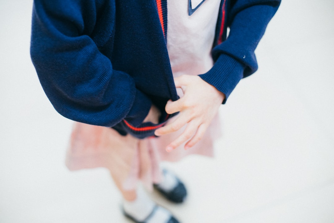 flocage uniforme scolaire personnalisé - woman tugging her blue jacket