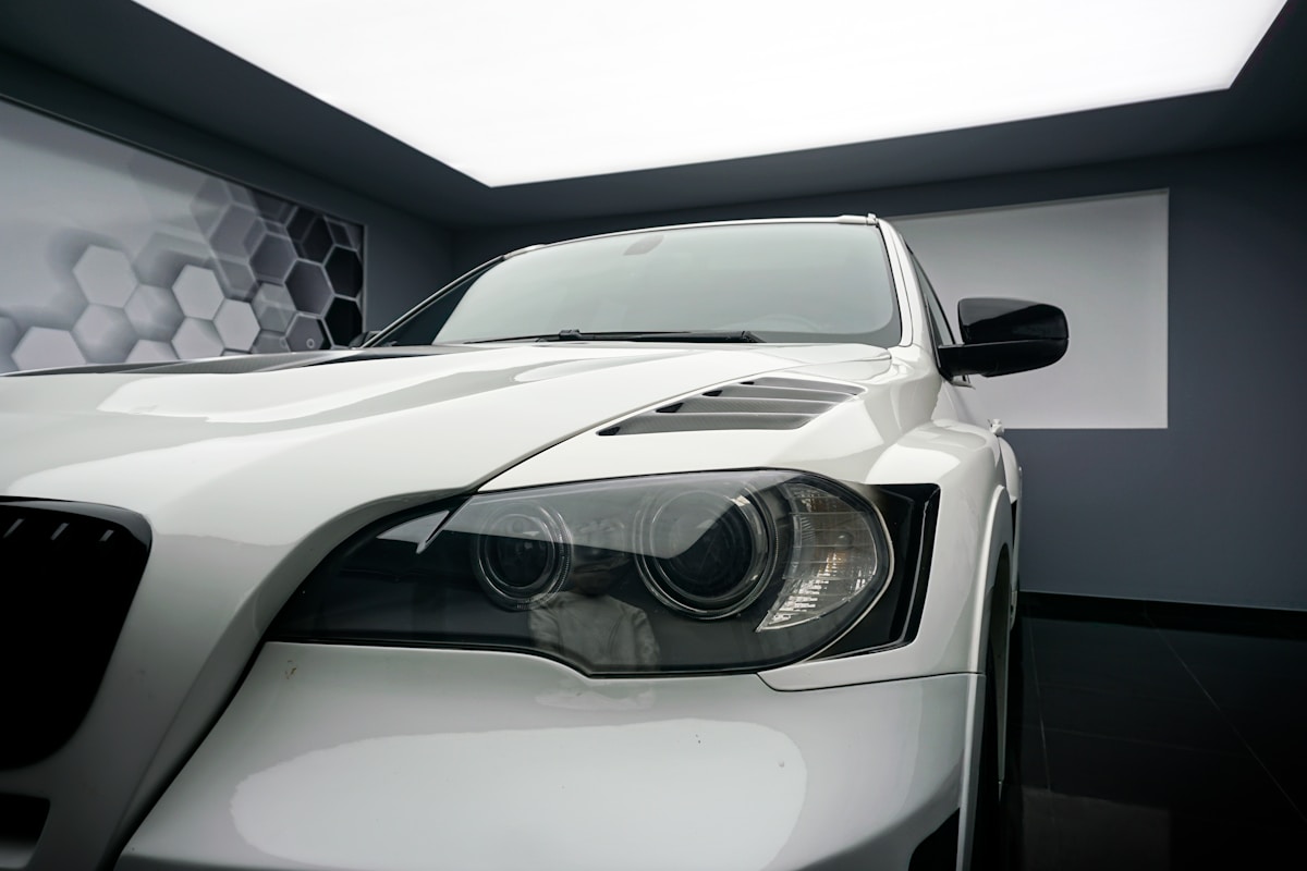 Voiture de sport blanche avec phares noirs et design aérodynamique.
