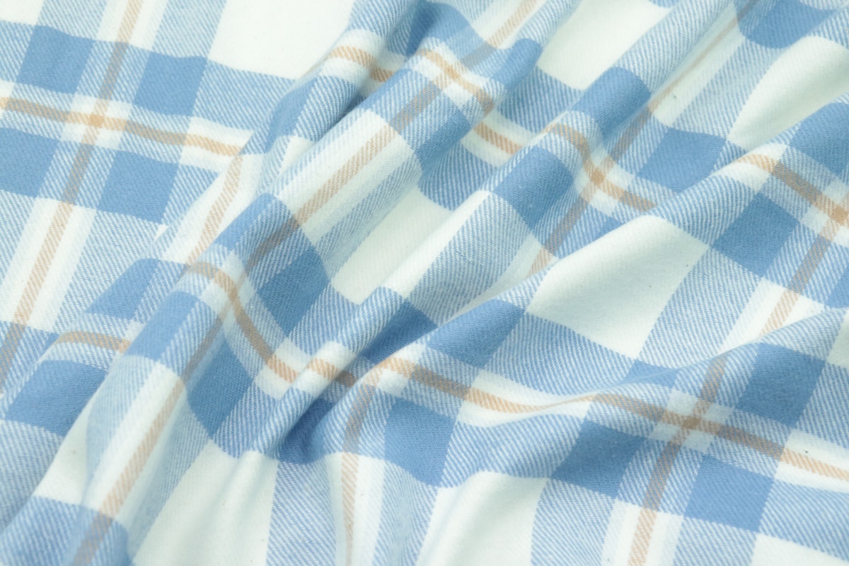 Tissu à motif de carreaux bleus et blancs avec des lignes diagonales.