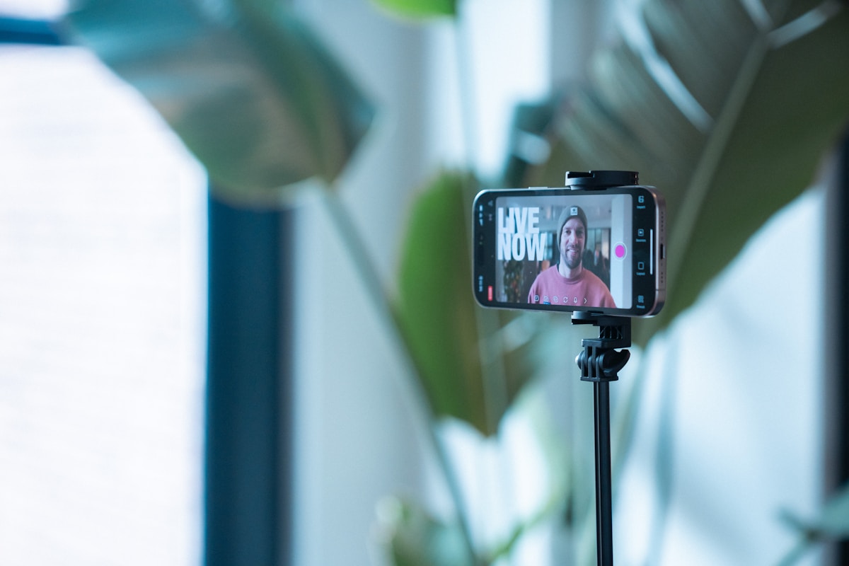 Smartphone monté sur un trépied, diffusion en direct sur l'écran.