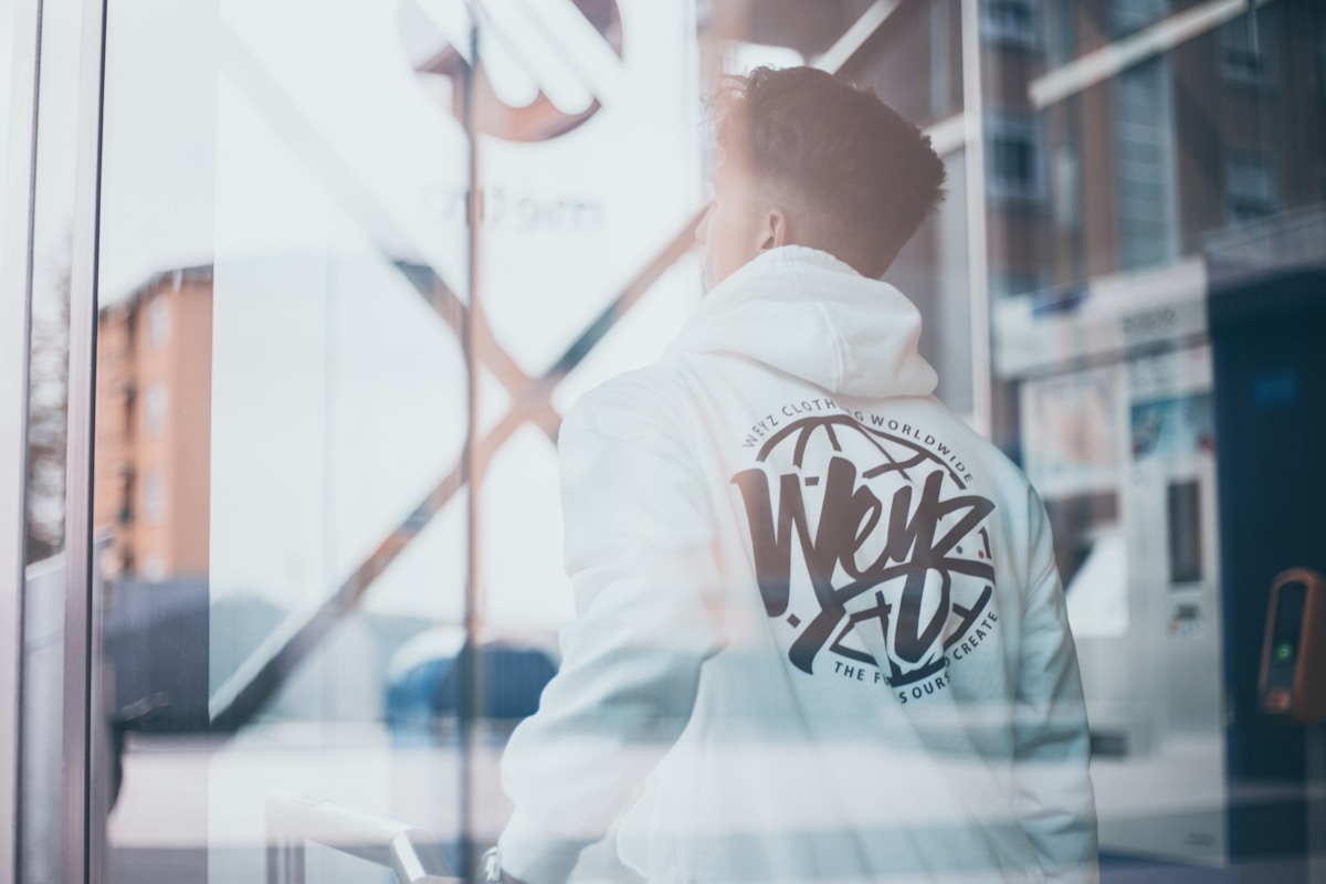 Homme en veste blanche avec logo de marque de vêtements.