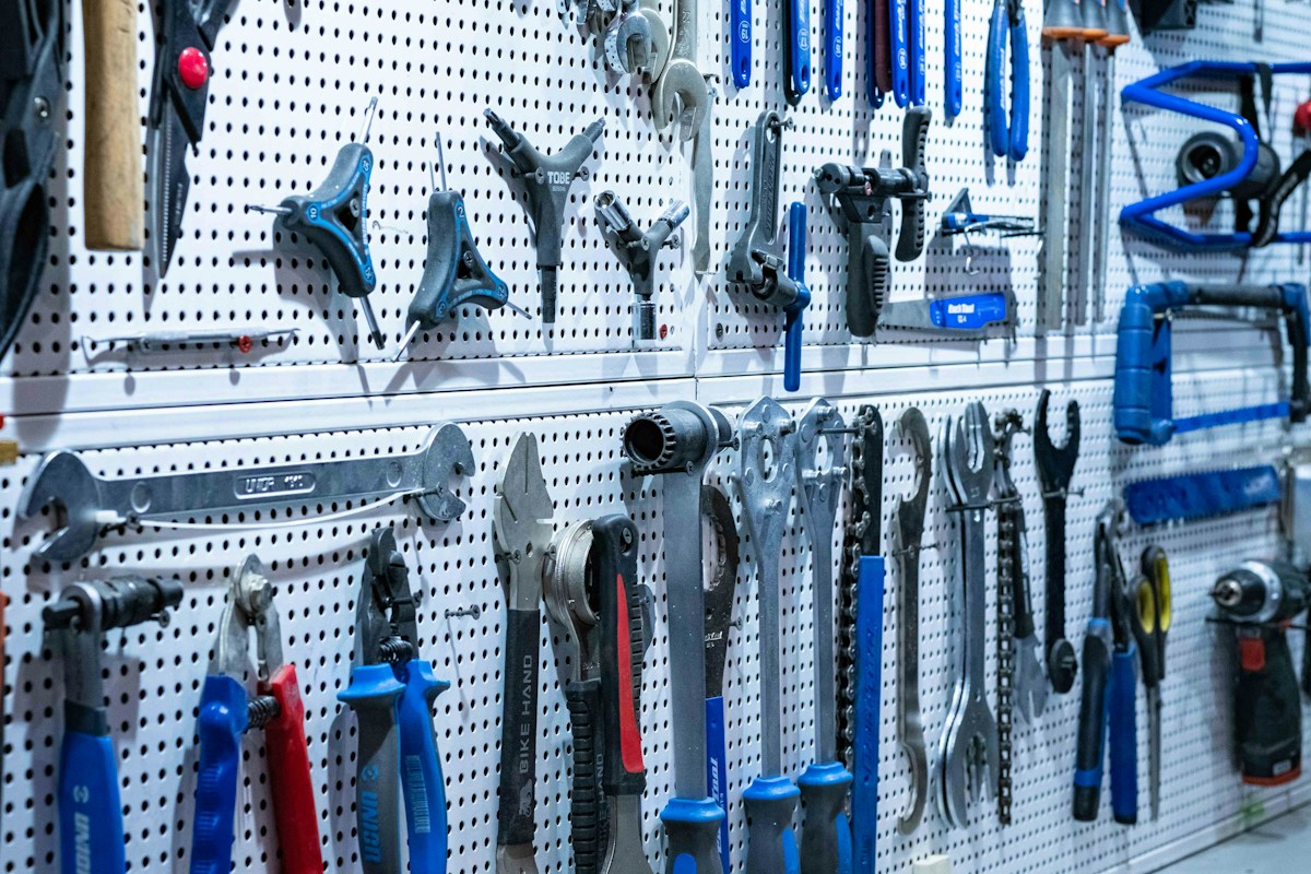 Mur perforé rempli d’outils de mécanique et de vélo suspendus